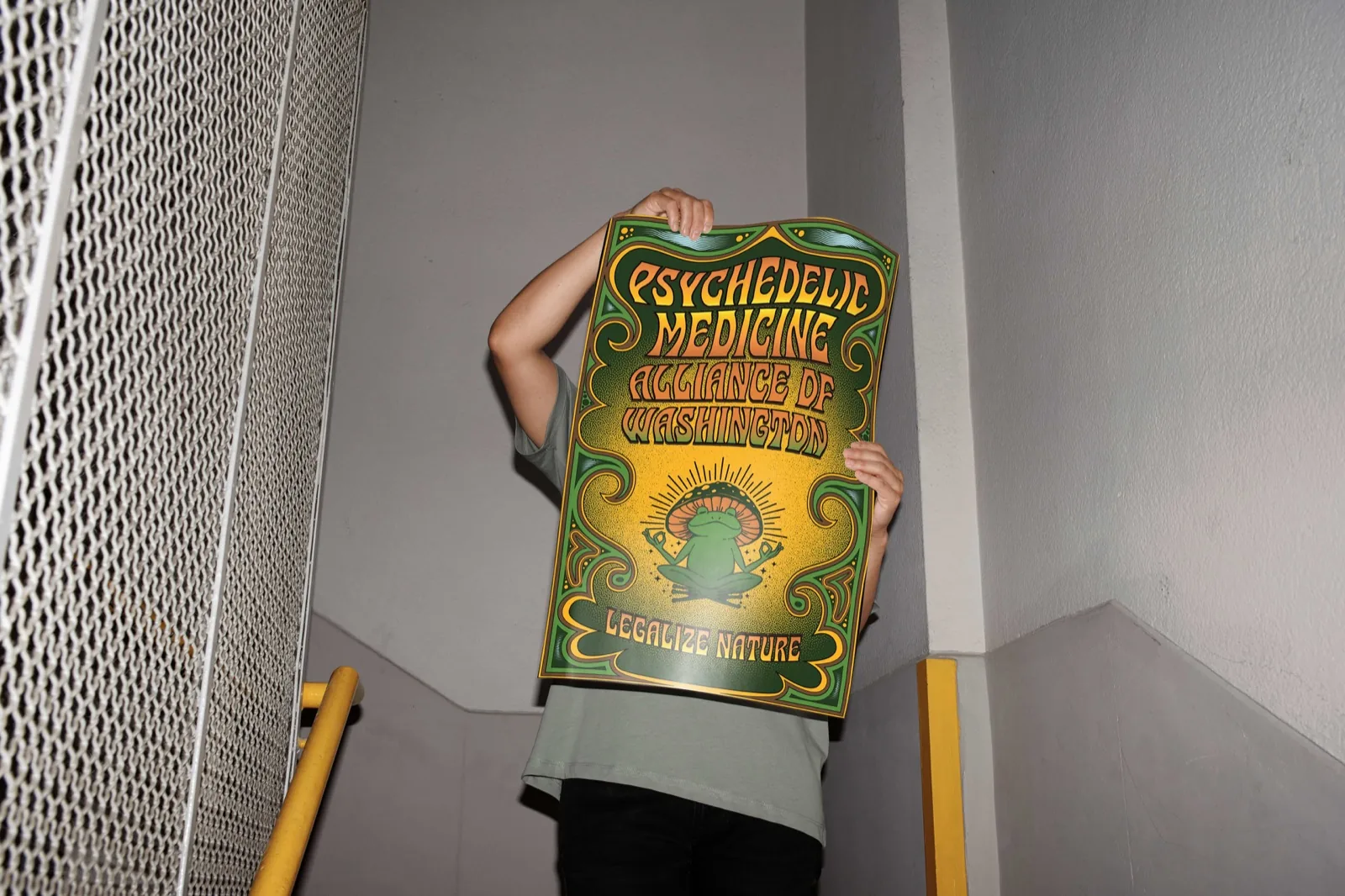 Holding up the Psychedelic Medicine Alliance of Washington poster